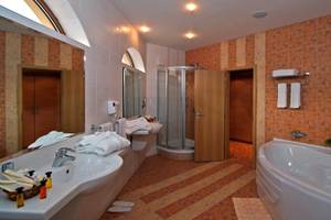 Badezimmer im Sol Nessebar Palace All Inclusive mit Badewanne, Dusche und zwei Waschbecken.