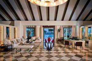 Empfangsbereich des Gran Melia Palacio de Isora mit modernen Möbeln und Blick auf den Pool.