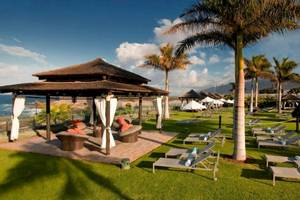 Gran Melia Palacio de Isora Hotel Lounge Bereich mit Liegestühlen und einem Pavillon am Strand