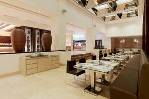 Innenansicht des Restaurants im Gran Melia Palacio de Isora Hotel mit runden Vasen und gefliestem Boden.