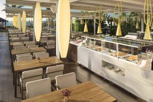 Restaurantbereich des Gran Melia Palacio de Isora mit Tischen, Stühlen und Speisen