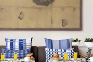 Frühstückstisch im Gran Melia Palacio de Isora mit zwei Gläsern Orangensaft und Brötchen