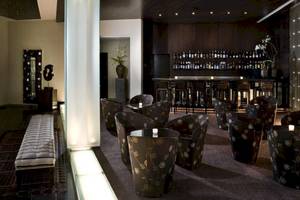 Hotellounge des Gran Melia Palacio de Isora mit dekorierten Stühlen und einer Bar.