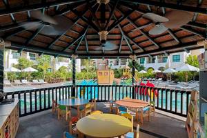 Kinder Spielbereich im Gran Melia Palacio de Isora Hotel mit bunten Tischen und Spielgeräten.