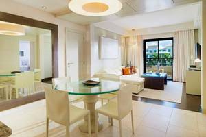 Innenbereich des Gran Melia Palacio de Isora mit Esstisch und Wohnzimmer.