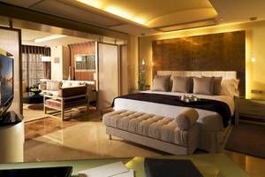 Gran Melia Palacio de Isora Suite Zimmer mit Bett, Sofa und Schreibtisch.