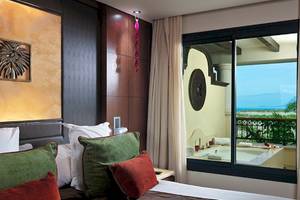Zimmer im Gran Melia Palacio de Isora mit Blick auf einen Whirlpool und das Meer.