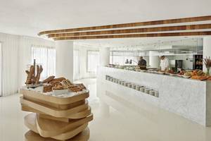 Frühstücksbuffet im Hyatt Place Taghazout Bay Hotel mit verschiedenen Gerichten und zwei Köchen im Hintergrund.