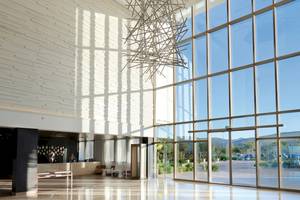 Lobby des Hyatt Place Taghazout Bay Hotels mit großen Fenstern und moderner Einrichtung.
