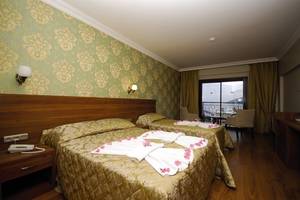 Doppelzimmer im Meril Hotel mit zwei Betten, Balkon, und Blick auf den See.
