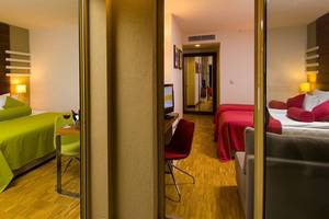 Innenansicht eines Hotelzimmers im Blue Waters Club mit zwei Betten, Schreibtisch und Fernseher.