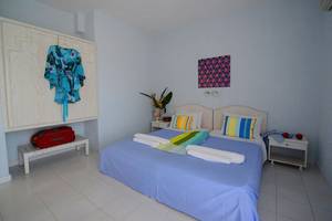 Schlafzimmer im Golden Star Hotel in Kos mit blauem Bett und weißen Möbeln.