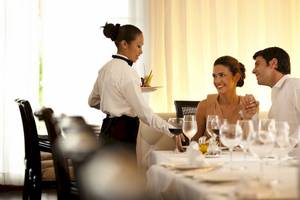 Ein Kellner serviert ein Paar im Restaurant des Barcelo Maya Palace