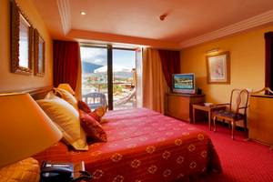Schlafzimmer im Botanico & The Oriental Spa Garden Hotel mit rotem Bett und Blick auf den Balkon