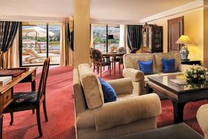 Wohnzimmer im Botanico & The Oriental Spa Garden Hotel mit gelben Wänden, rotem Teppich und blauen Kissen.