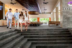 Vier Personen, zwei Paare, gehen die Stufen zur Mall Bar im Barcelo Maya Palace Hotel hinauf.