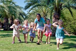 Kleine Kinder laufen mit Bällen im Freien im Belambra Clubs Pineto.