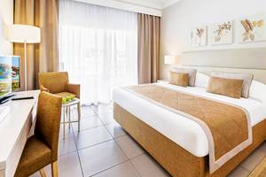Ein Hotelzimmer im Jaz Aquaviva mit einem Bett, Schreibtisch und Stühlen.
