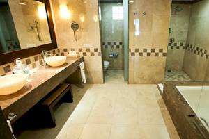Ein modernes Badezimmer im Barcelo Maya Palace Hotel mit zwei Waschbecken, einem Spiegel, einer Dusche und einer Badewanne.
