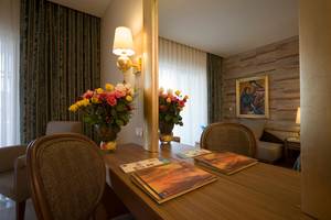 Zimmer mit Tisch, Blumen und Spiegel im Melas Lara Hotel.