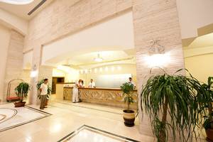 Empfangsbereich des Melas Lara Hotels mit Rezeption und Gästen.