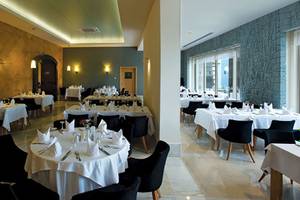 Foto von einem eleganten Restaurant im Melas Lara Hotel mit gedeckten Tischen und modernen Möbeln.