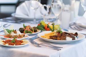 Mehrere Teller mit verschiedenen Speisen auf einem gedeckten Tisch im Melas Lara Hotel.