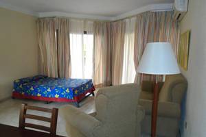 Hotelzimmer im ROC Arenas Doradas mit Bett, Stühlen, Tisch und Lampe.
