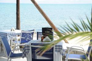 Strandrestauranttisch mit Menü und Blick auf das Meer, Mastichari Bay