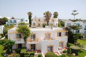 Luftaufnahme des Mastichari Bay Hotels mit mehreren weißen Gebäuden und gelben Akzenten.