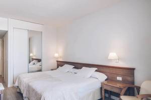 Hotelzimmer im Iberostar Las Dalias mit zwei Betten, Fernseher, Nachttisch und Spiegel.