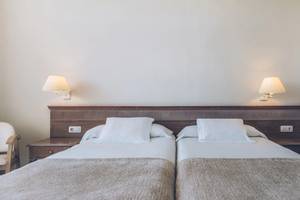 Doppelbettzimmer im Iberostar Las Dalias Hotel mit weißen Laken und Kissen.
