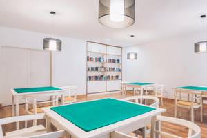 Speisesaal im Iberostar Las Dalias Hotel mit weißen Tischen und Stühlen, Bücherregal und Deckenlampen.