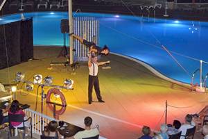 Akrobaten führen eine Show über einem Swimmingpool im Sol Barbados Hotel auf.