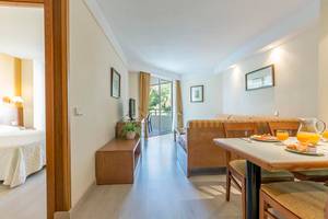 Innenansicht einer Suite im Hipotels Bahia Grande, mit Schlafzimmer, Wohnzimmer und Balkon.
