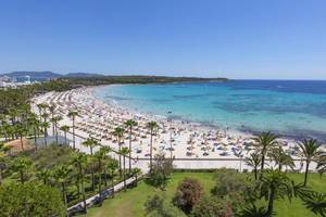 Luftaufnahme des Hipotels Bahia Grande Strandes mit vielen Gästen, Palmen und türkisfarbenem Meer