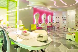 Innenansicht des Temptation Cancun Resort Nagelstudios mit pinken Wänden und grünen Akzenten.