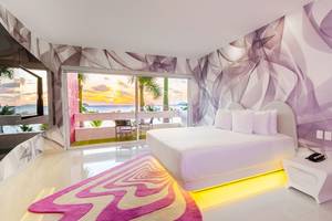 Innenansicht eines Hotelzimmers im Temptation Cancun Resort mit Blick auf das Meer und eine Terrasse.