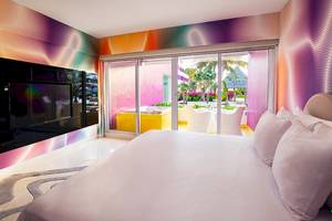 Schlafzimmer im Temptation Cancun Resort mit bunten Wänden, einem großen Bett und einer Terrasse