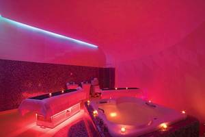 Spa-Bereich im Temptation Cancun Resort mit zwei Behandlungstischen und einer großen Badewanne.