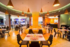 Innenansicht des Restaurants im Temptation Cancun Resort mit runden Tischen und Stühlen.