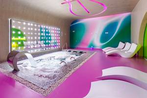 Innenbereich des Temptation Cancun Resorts mit einem Whirlpool und bunten Wänden.