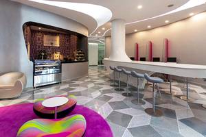 Innenbereich des Temptation Cancun Resorts mit einer Café-Bar, modernen Stühlen und einer gemusterten Bodenfläche.