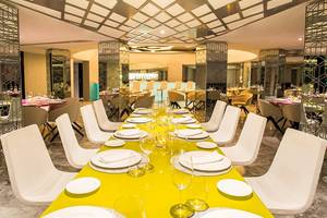 Restaurantbereich im Temptation Cancun Resort mit langer Tafel und weißen Stühlen.