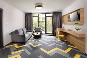 Innenansicht des HVD Club Bor Hotels mit Wohnzimmer, Schlafbereich und modernem Design.