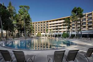 Außenbereich des HVD Club Bor Hotels mit Swimmingpool und Sonnenliegen.