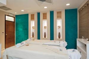 Spa-Behandlungsraum im Iberostar Selection Varadero mit zwei Massageliegen, blauen Wänden und weißen Möbeln.