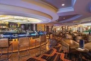 Innenansicht der Bar im Caesars Palace Hotel mit runden Tischen und Stühlen.