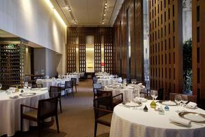 Ein elegantes Restaurant im Caesars Palace mit weißen Tischdecken, Glasflaschen und Holzwänden.