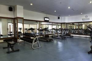 Fitnesscenter im Adalya ArtSide Hotel mit verschiedenen Geräten und Spiegeln.